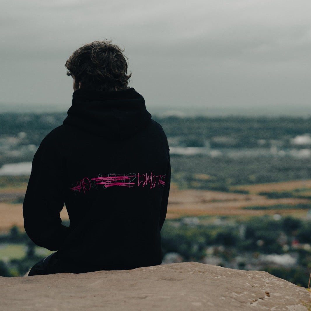 Man sat on cliff edge wearing a THL Hybrid Heavyweight Hoodie