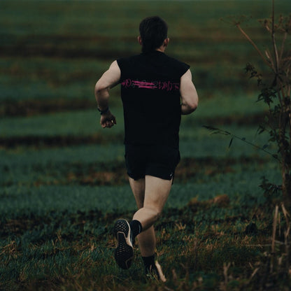 Man running through a field wearing a THL Hybrid Tank