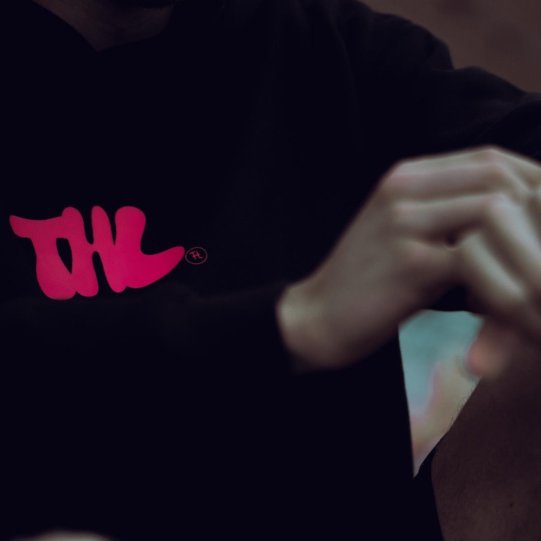 Man wearing THL Hybrid Heavyweight hoodie playing with watch