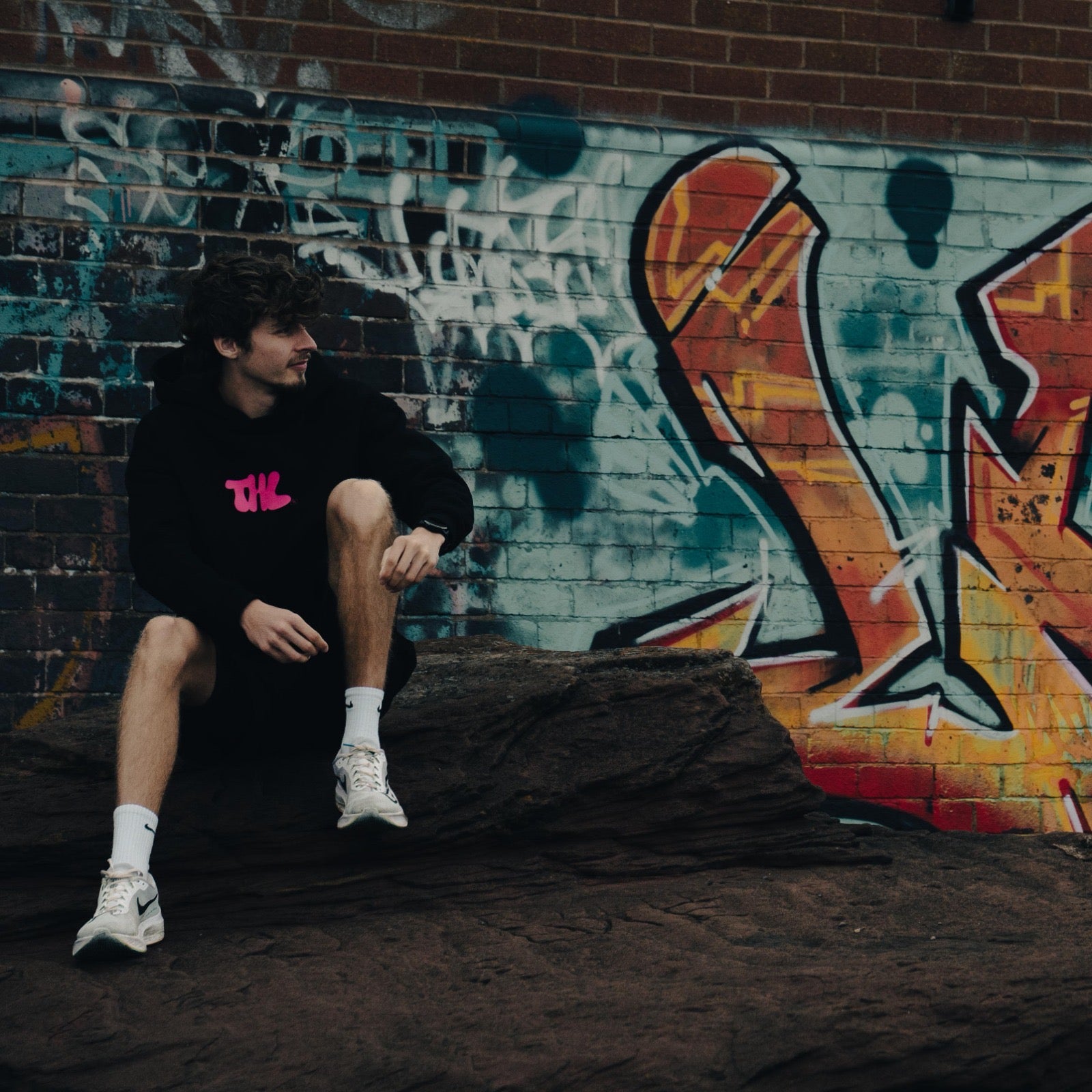 Man wearing Hybrid Hoodie in front of graffiti covered wall